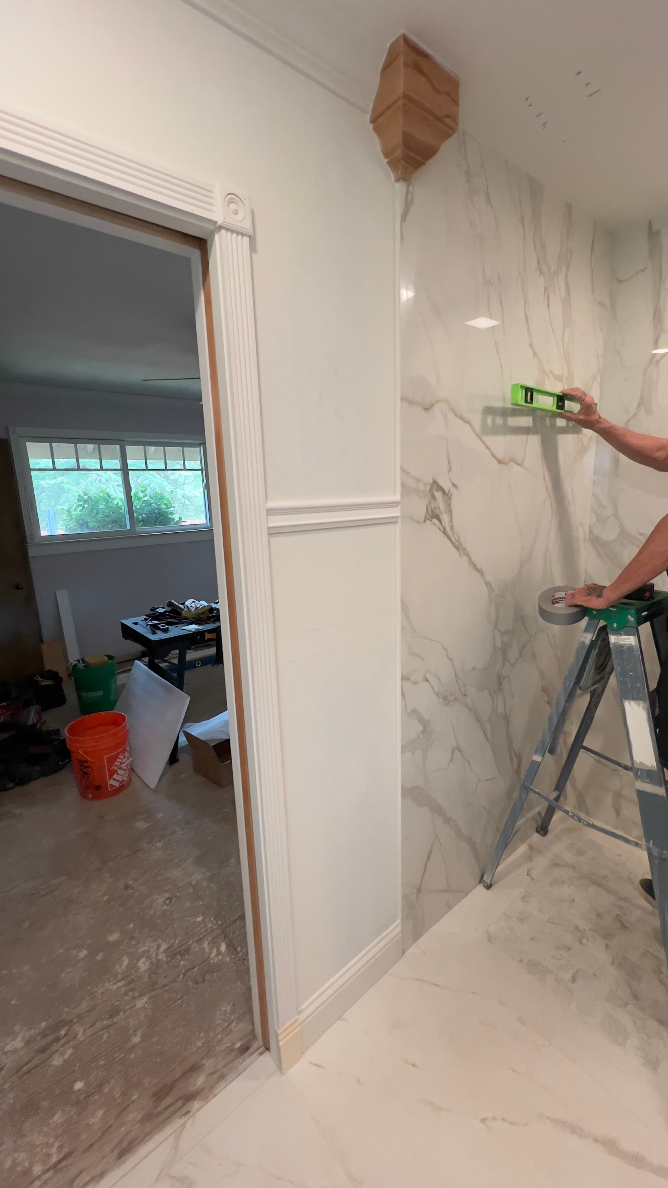 Worker measuring marble wall tile during custom bathroom renovation — GT Home Solution in Amador County, CA