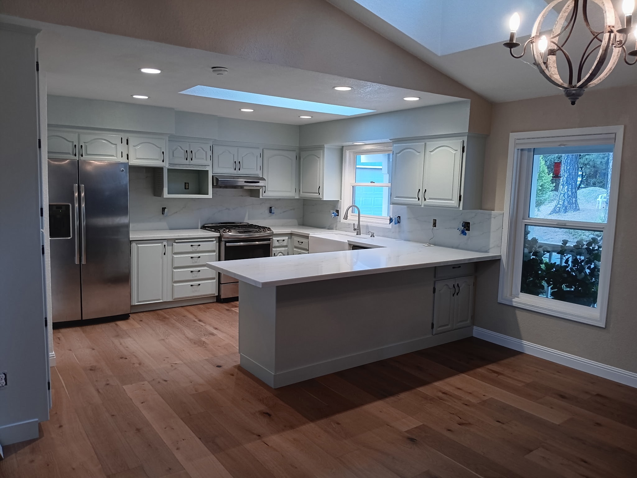 Classic kitchen remodel with white cabinetry, quartz countertops, farmhouse sink, and hardwood floors — GT Home Solution in Amador County, CA