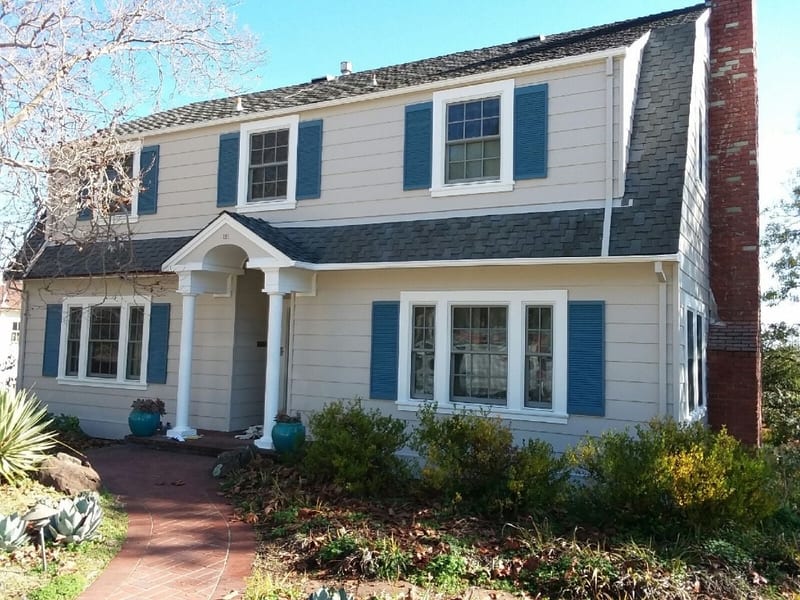 Two-story home with cream siding, blue shutters, and covered entry — exterior repaint and remodel by GT Home Solution in Pioneer, CA