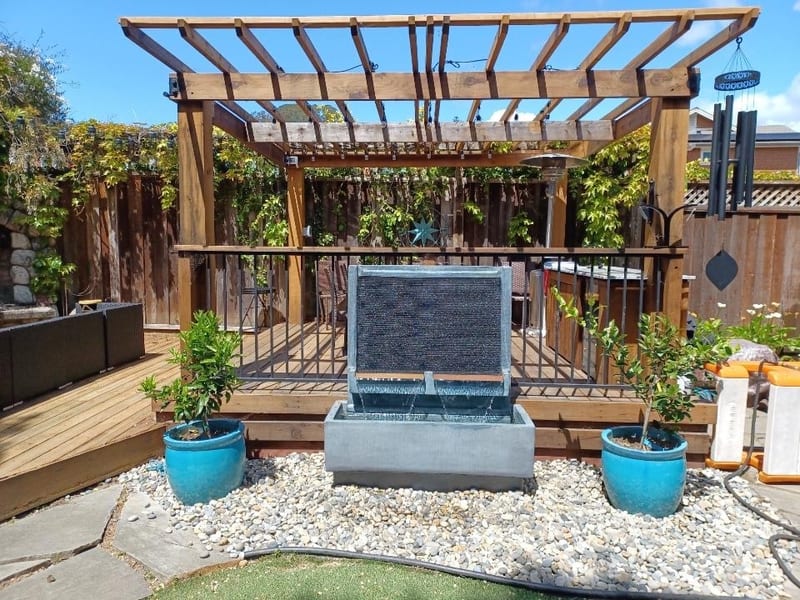 Custom wood pergola with water feature and stamped concrete patio — outdoor living addition by GT Home Solution in Pioneer, CA
